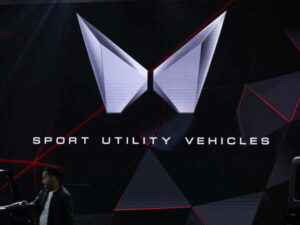 a-man-stands-next-to-a-screen-displaying-mahindras-logo-at-bharat-mobility-global-expo-organised-by-indias-commerce-ministry-at-pragati-maidan-in-new-delhi