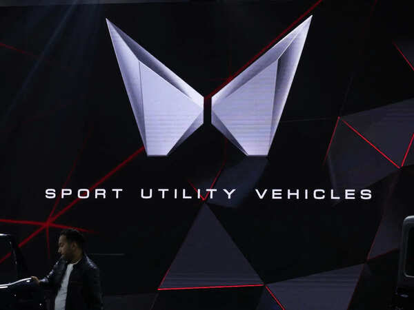 a-man-stands-next-to-a-screen-displaying-mahindras-logo-at-bharat-mobility-global-expo-organised-by-indias-commerce-ministry-at-pragati-maidan-in-new-delhi